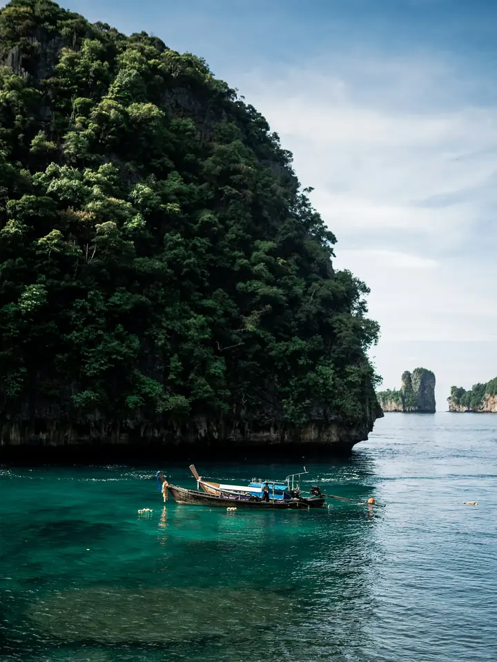 Bateau longue queue au pied d’une falaise, îles Phi Phi