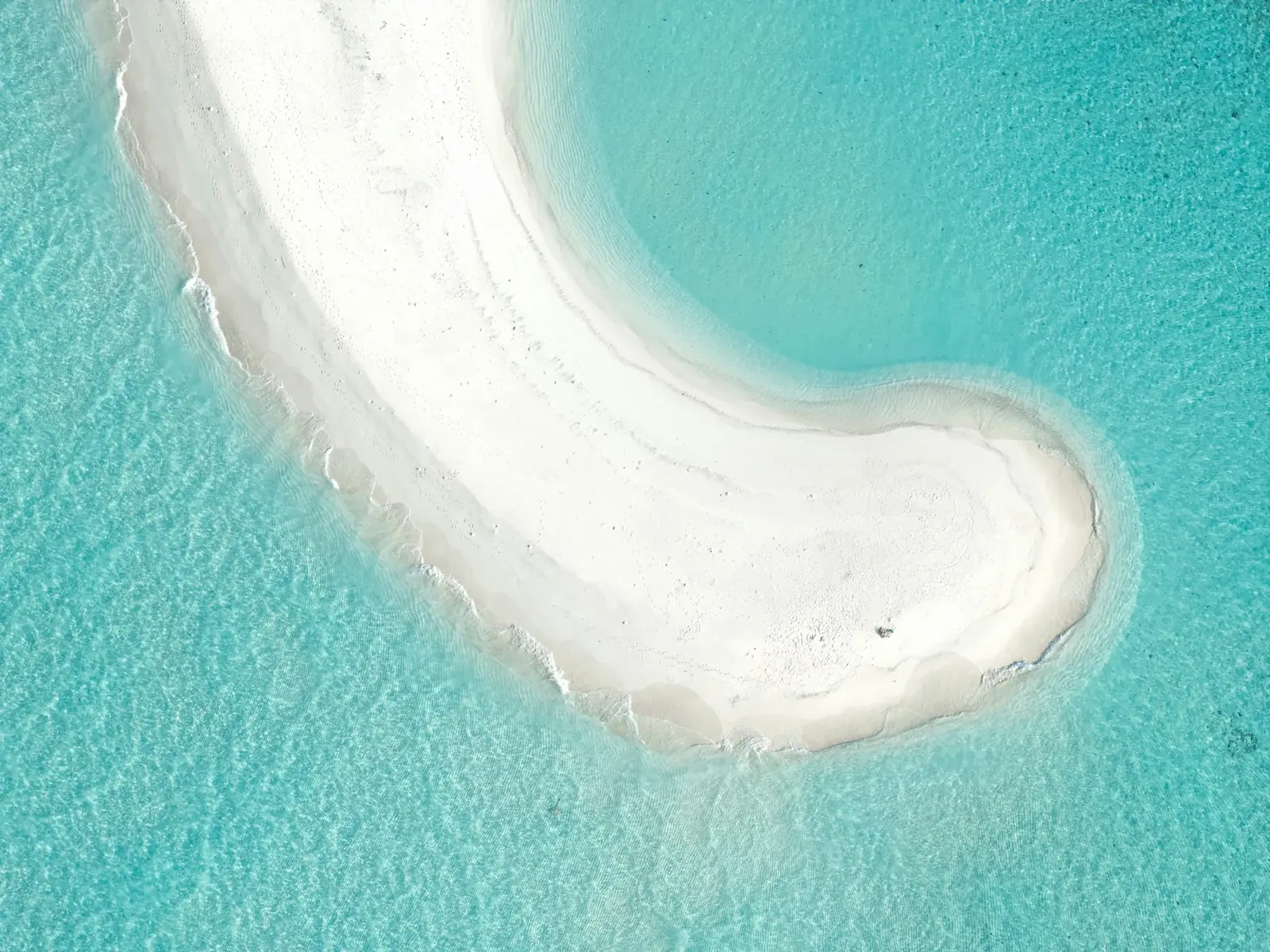 Banc de sable blanc isolé dans le lagon, vu du ciel
