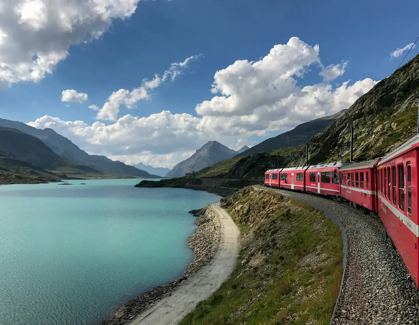 Train rouge longeant un lac au col de la Bernina