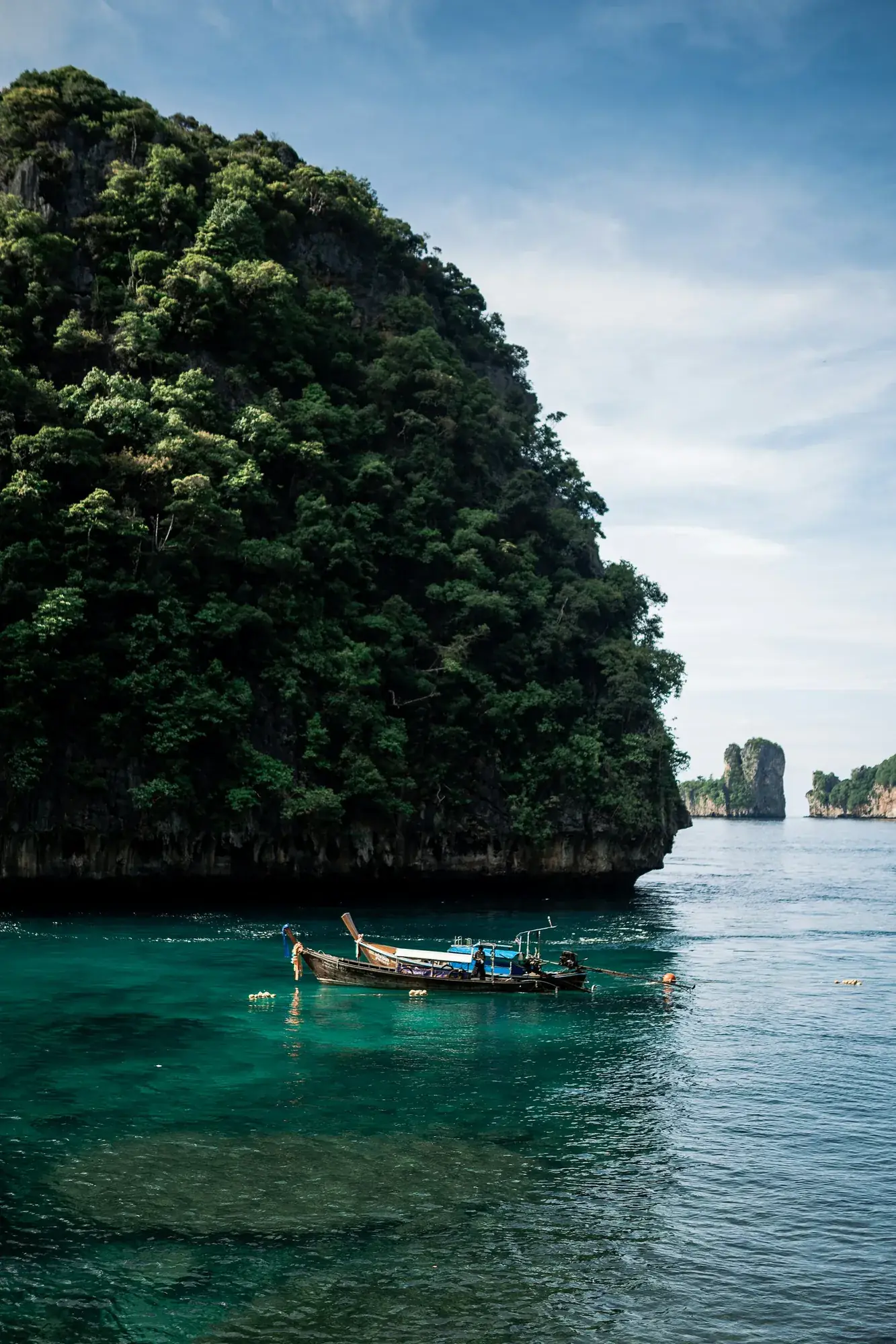 Bateau longue queue au pied d'une falaise, îles Phi Phi