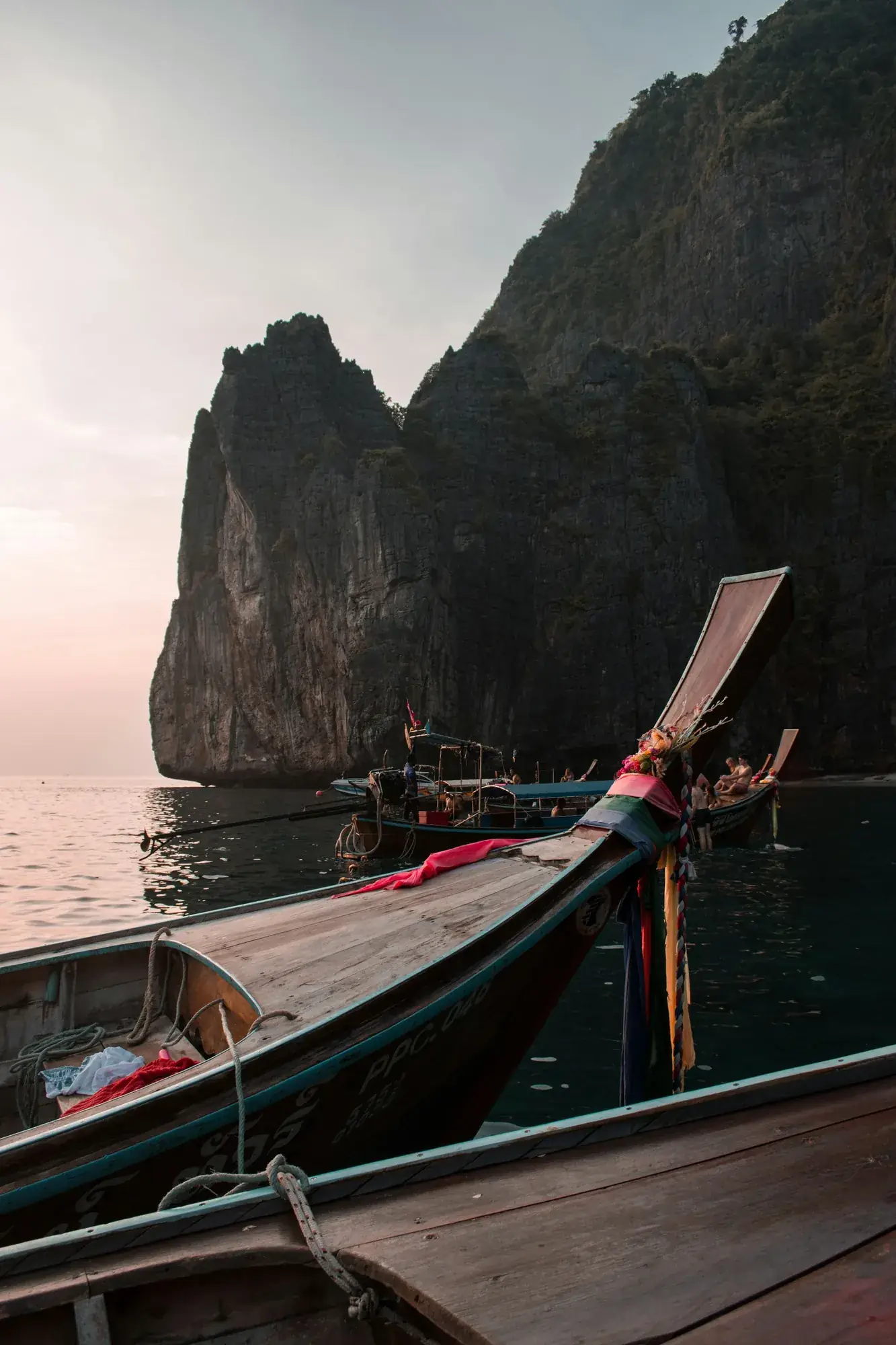 Proue d'un bateau longue queue face aux falaises, Phi Phi au soir